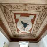 In una, alzando lo sguardo, restiamo incantati dal soffitto interamente affrescato con raffigurazioni dai colori caldi: rosso, dorato e rosa antico su uno sfondo bianco
